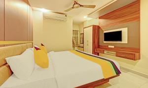 a bedroom with a bed and a flat screen tv at Itsy Hotels Sri Sai Grand Inn in Vijayawāda