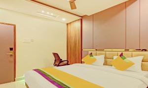 a hotel room with a bed and a chair at Itsy Hotels Sri Sai Grand Inn in Vijayawāda