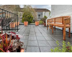 a patio with a wooden bench and potted plants at Highday House - A Place To Escape To in Totnes