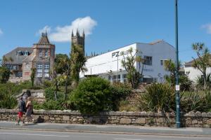 Camilla House Guest House في بينزانس: شخصان يقفان على جانب الشارع