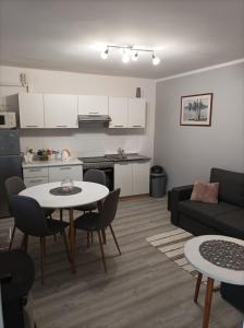 uma cozinha e uma sala de estar com mesa e cadeiras em Apartman Ana 1 em Valpovo