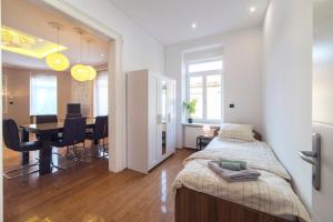 a bedroom with a bed and a dining room with a table at Agape Apartments in Zagreb