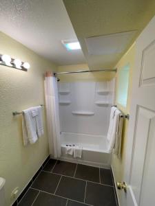a bathroom with a tub and a shower with towels at Vento Hotel in Hutchinson