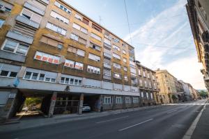 una strada vuota con un palazzo alto di Agape Apartments a Zagabria