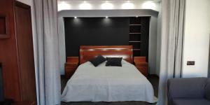 a bedroom with a bed with white sheets and black pillows at Apartment on Nazarbayeva 77 in Almaty