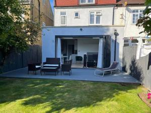 a patio with chairs and a table in a yard at A beautiful one bedroom flat with garden & parking in Mill Hill