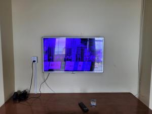 a flat screen tv hanging on a white wall at Cobertura vista mar in Maricá