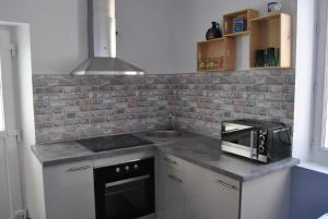 a kitchen with a counter top with a microwave at gîtes aux portes des Cévennes in Saint-Christol-lès-Alès