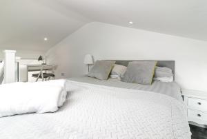 a white bedroom with two beds and a desk at King Pin Corner in Stevenage