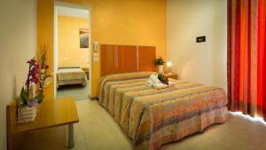 a hotel room with a bed and a table at Hotel Venezia in Caorle