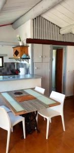 eine Küche mit einem Tisch und 2 weißen Stühlen in der Unterkunft Villa de 2 chambres a Porto Vecchio a 500 m de la plage avec vue sur la mer piscine partagee et jardin amenage in Porto-Vecchio