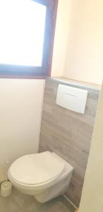 a white toilet in a bathroom with a window at Villa de 2 chambres a Porto Vecchio a 500 m de la plage avec vue sur la mer piscine partagee et jardin amenage in Porto-Vecchio