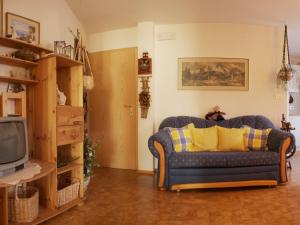 a living room with a couch and a tv at Appartements Sonnengarten in Tirolo