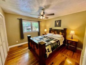 Schlafzimmer mit einem Bett und einem Deckenventilator in der Unterkunft Cozy Creekside cabin- 35m to Boone in Butler