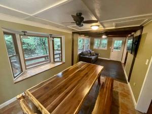 ein Wohnzimmer mit einem Holztisch und Fenstern in der Unterkunft Cozy Creekside cabin- 35m to Boone in Butler