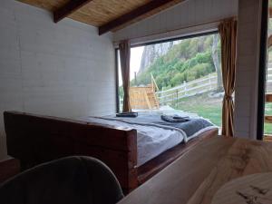 uma cama num quarto com uma grande janela em Cabana Everest View Buces -Vulcan Apuseni 