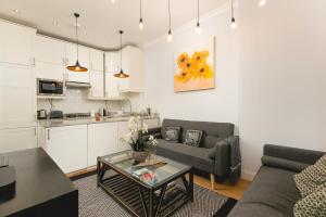 uma sala de estar com um sofá e uma mesa em PenthouseStays Notting Hill - Spacious 3 Bedroom King Bed Apartment - near Portobello Road & Kensington High Street em Londres