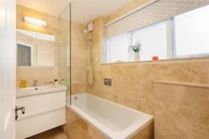 y baño con bañera, lavamanos y ducha. en PenthouseStays Notting Hill - Spacious 3 Bedroom King Bed Apartment - near Portobello Road & Kensington High Street, en Londres