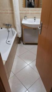 a bathroom with a sink and a tub and a toilet at Alvor Vila da Praia in Alvor