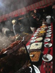 a buffet line with many plates of food at Wadi Rum Fire Camp in Wadi Rum