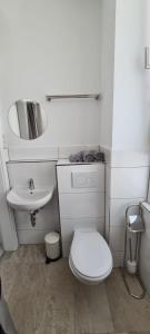 a white bathroom with a toilet and a sink at Engel Apartments Baden-Baden in Baden-Baden