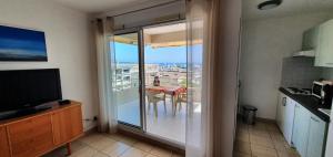 a kitchen with a sliding glass door to a balcony at Standing vue mer entre Cannes et Antibes in Golfe-Juan