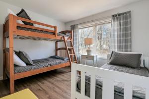 a bedroom with bunk beds and a desk at 3 BR Private Pondside View New Reno [Moose Lodge] in Bar Harbor