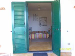 une porte verte menant à une chambre avec un lit dans l'établissement Casa U' Cucunciu, à Lipari