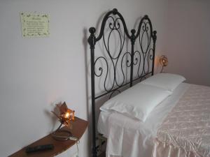 ein Schlafzimmer mit einem Bett und einem Tisch mit einer Lampe in der Unterkunft B&B Anima Natura in Modena