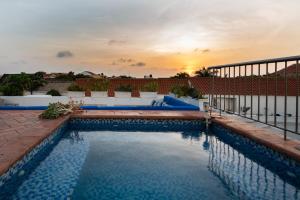 a swimming pool with a sunset in the background at Amazing 6BR 2 Pools Sundeck BBQ inside Centro Historico b in Cartagena de Indias