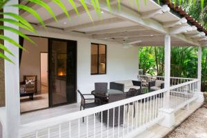 une terrasse blanche avec pergola sur une maison dans l'établissement Bodhi Tree Yoga Resort, à Nosara