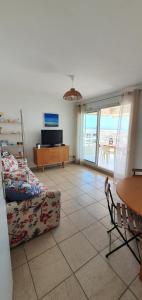 sala de estar con sofá y mesa en Standing vue mer entre Cannes et Antibes, en Golfe-Juan