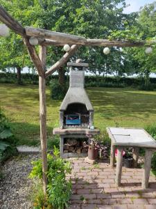 einen Grill im Freien mit einem Picknicktisch und einer Bank in der Unterkunft San Jacobi in Eijsden