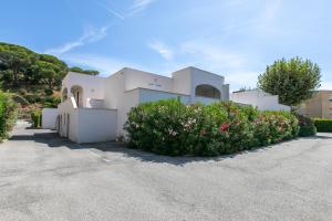 a white house with a bunch of flowers in the driveway at Beach Cannes Bungalows in Le Cannet