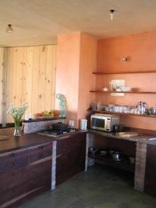 a kitchen with wooden cabinets and a stove top oven at Casa Dos Milagres Holiday Home in Agulhas