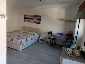 1 dormitorio con cama, escritorio y mesa en Maison De Marie en Donnaz
