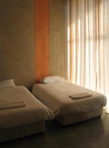 2 camas en una habitación con ventana en Casa Dos Milagres Holiday Home en Agulhas