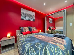 ATELIER DES REVES - au coeur de Besancon - 88 m2 في بيزنسون: غرفة نوم بسرير كبير وبجدران حمراء