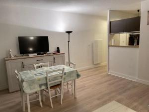 a living room with a dining room table and a television at LES TERRASSES DE LA MER - PARKING - WIFI - CLIM - accès privé plage - point zéro in La Grande-Motte