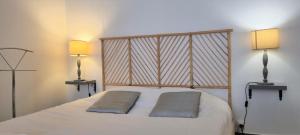 ein Schlafzimmer mit einem weißen Bett mit zwei Lampen in der Unterkunft Little Suite - Suzanne in Lille