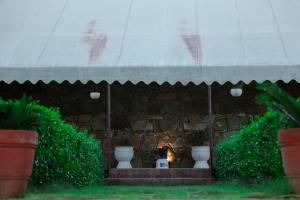 um edifício de tijolos com lareira com três vasos em The Rustic Villa, a stay with luxuries amenities and exotic nature em Jaipur