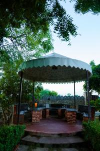 einen Pavillon mit einem Tisch und Stühlen in einem Park in der Unterkunft The Rustic Villa, a stay with luxuries amenities and exotic nature in Jaipur