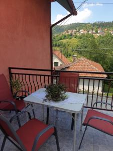 una mesa y sillas en un balcón con vistas en Kod nane Cane, en Nova Varoš