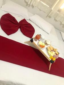 a tray of food on a bed with a bow tie at Hotel Brisa do Meireles in Fortaleza