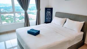 een bed met een blauw kussen in een slaapkamer bij Ais-Kacang Sweet Home Pinnacle Tower in Johor Bahru