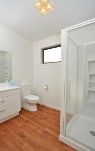 a bathroom with a toilet and a glass shower at Holiday home Queen Charlotte in Anakiwa