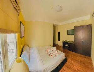 Un dormitorio con una cama con flores rojas. en Sai Gon Hotel Bui Vien Walking Street en Ho Chi Minh