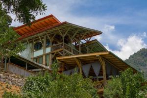 a house on top of a hill with trees at Bambu Guest House in Tzununá