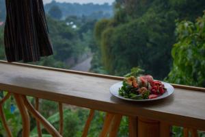a plate of food sitting on a rail on a balcony at Bambu Guest House in Tzununá