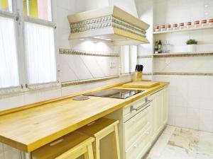 eine Küche mit einer Arbeitsfläche aus Holz und einem Waschbecken in der Unterkunft Beyourself by SevillaLuxurySuites in Sevilla